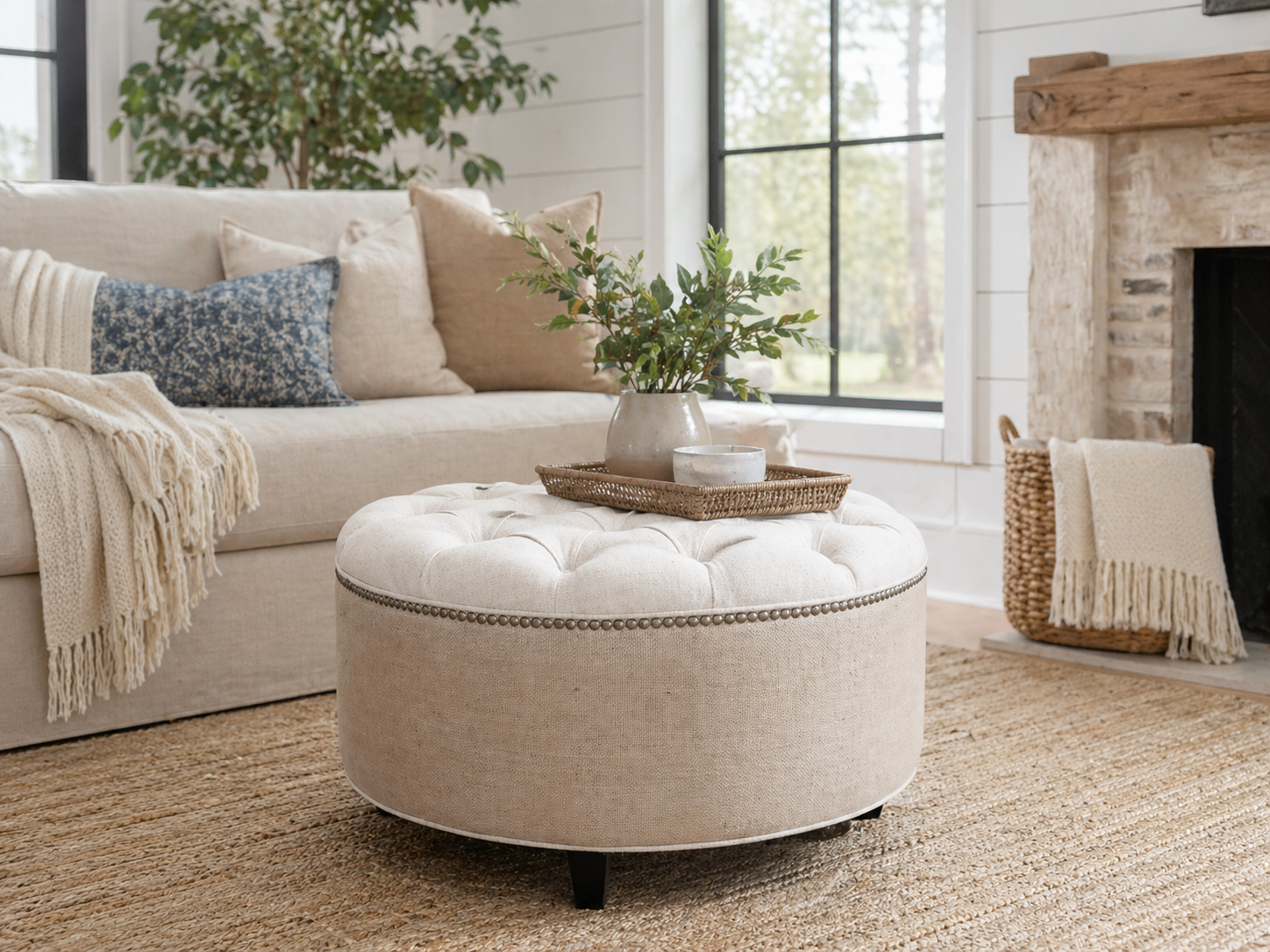 Living room with beige sofa, ottoman, and decorative items.