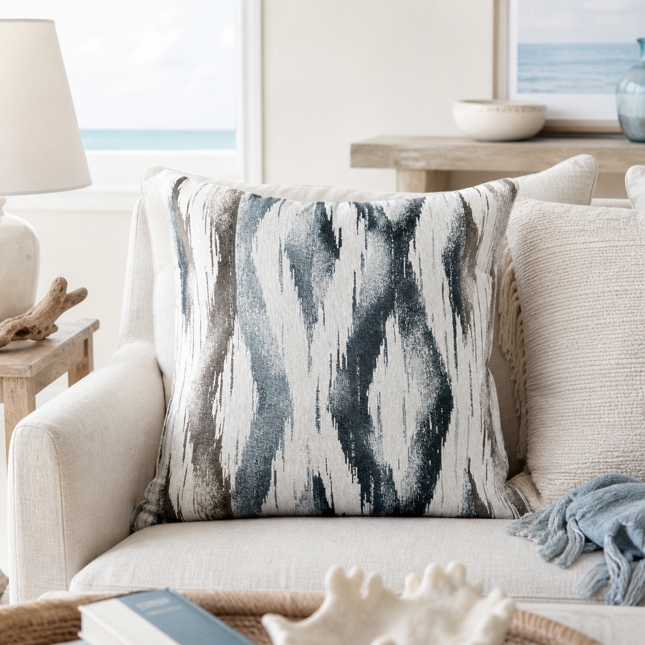 Coastal blue ikat decorative throw pillow on a white sofa